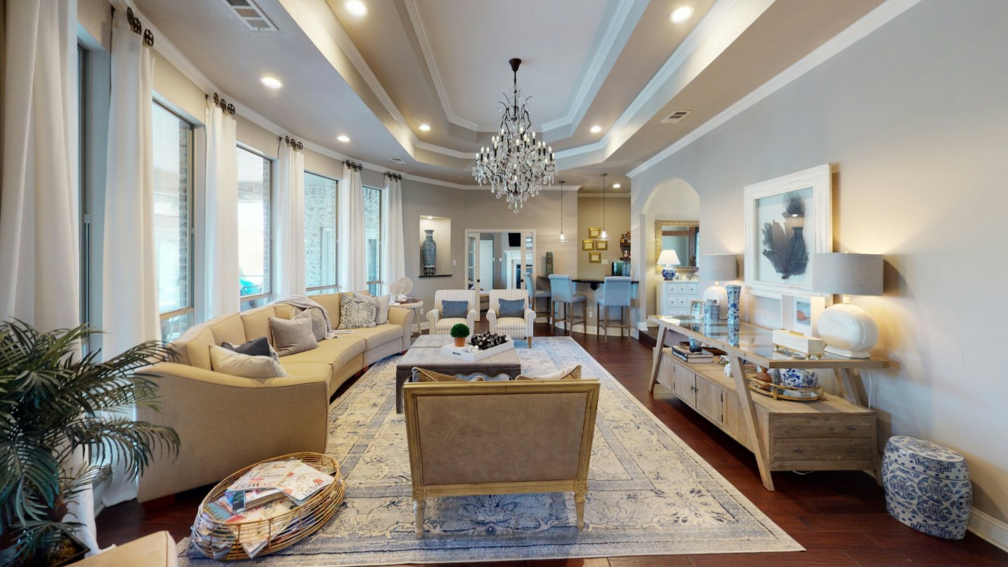 Spacious living room with curved sofa and bar area.