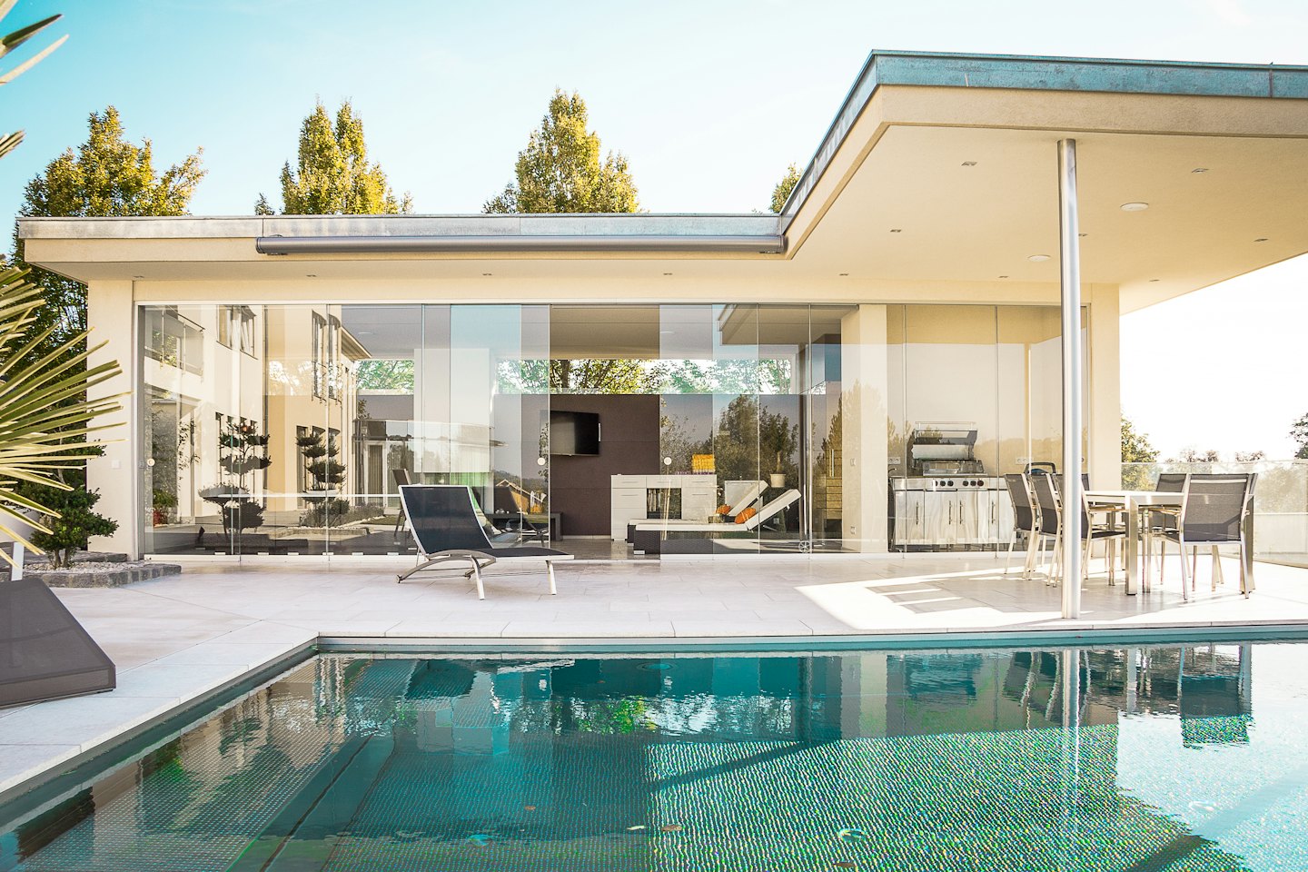 Modern house with swimming pool and outdoor kitchen.