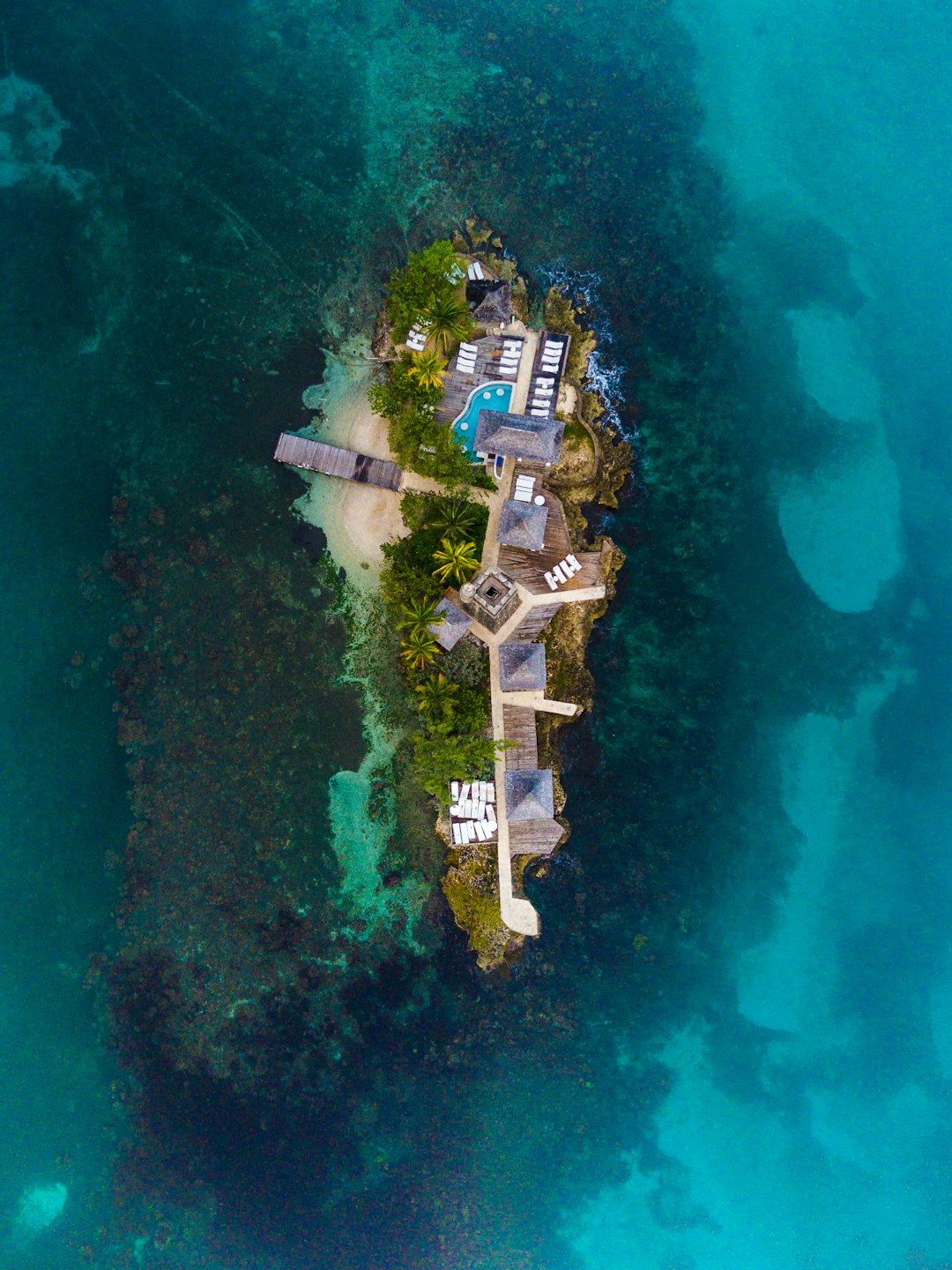 Luxurious island resort surrounded by clear ocean waters and coral.